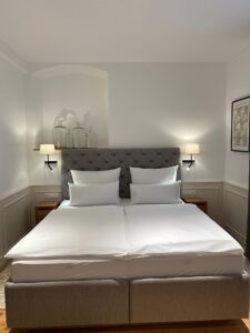 Bright modern hotel room with double bed and neutral tones
