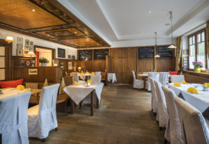 Bright traditional dining area with white tablecloths and yellow napkins
