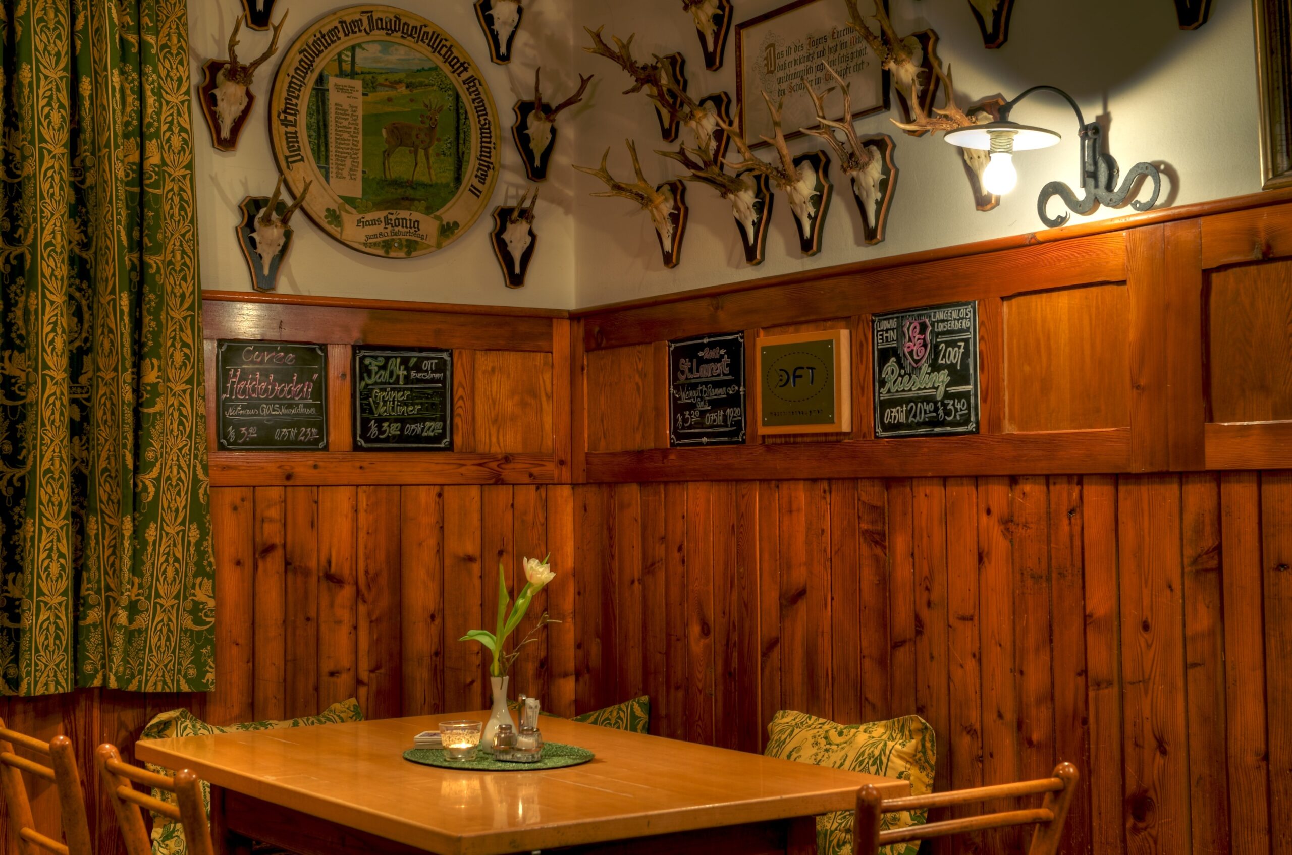 Hunting-themed dining room with mounted antlers and rustic wooden interior
