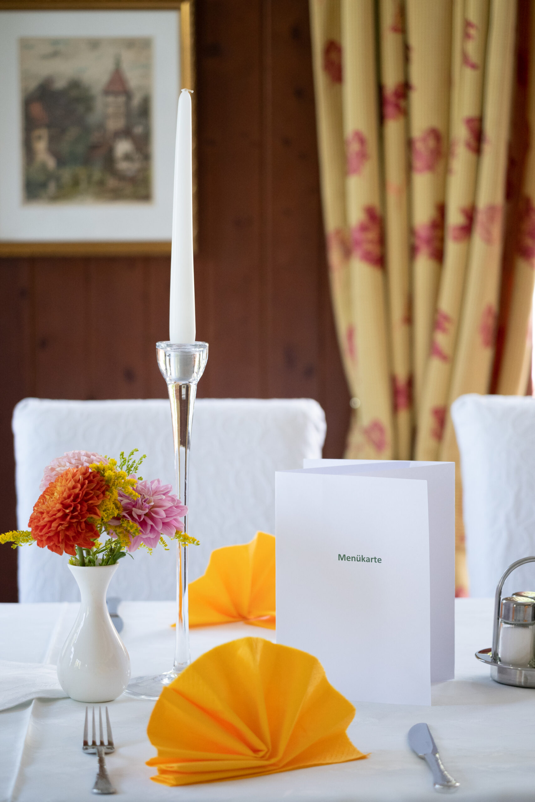 Elegant table setup with flowers, menu card, and wine glasses
