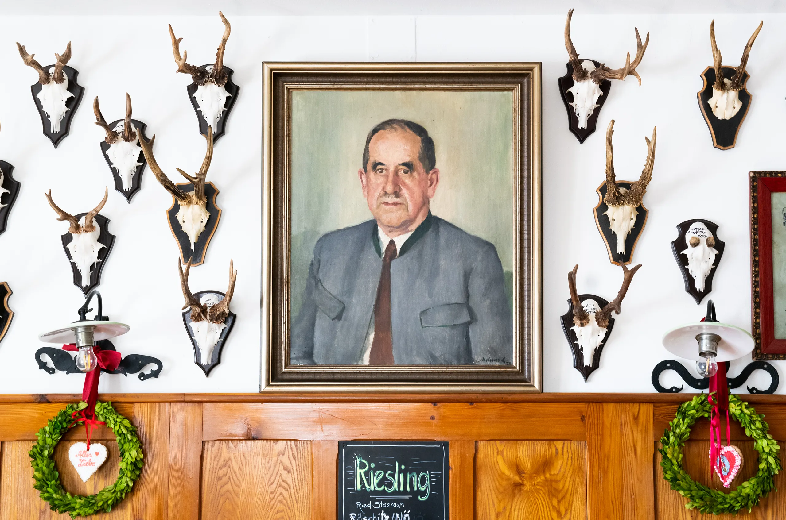 Historisches Porträt vom Opa König inmitten einer Sammlung traditioneller Jagdtrophäen im Gasthof König