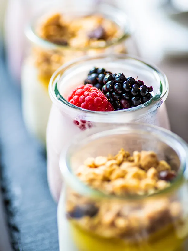 Joghurt im Glas mit frischen Beeren und knusprigem Granola.