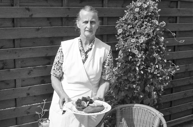 Oma König mit einem frisch zubereiteten Gericht im Gastgarten