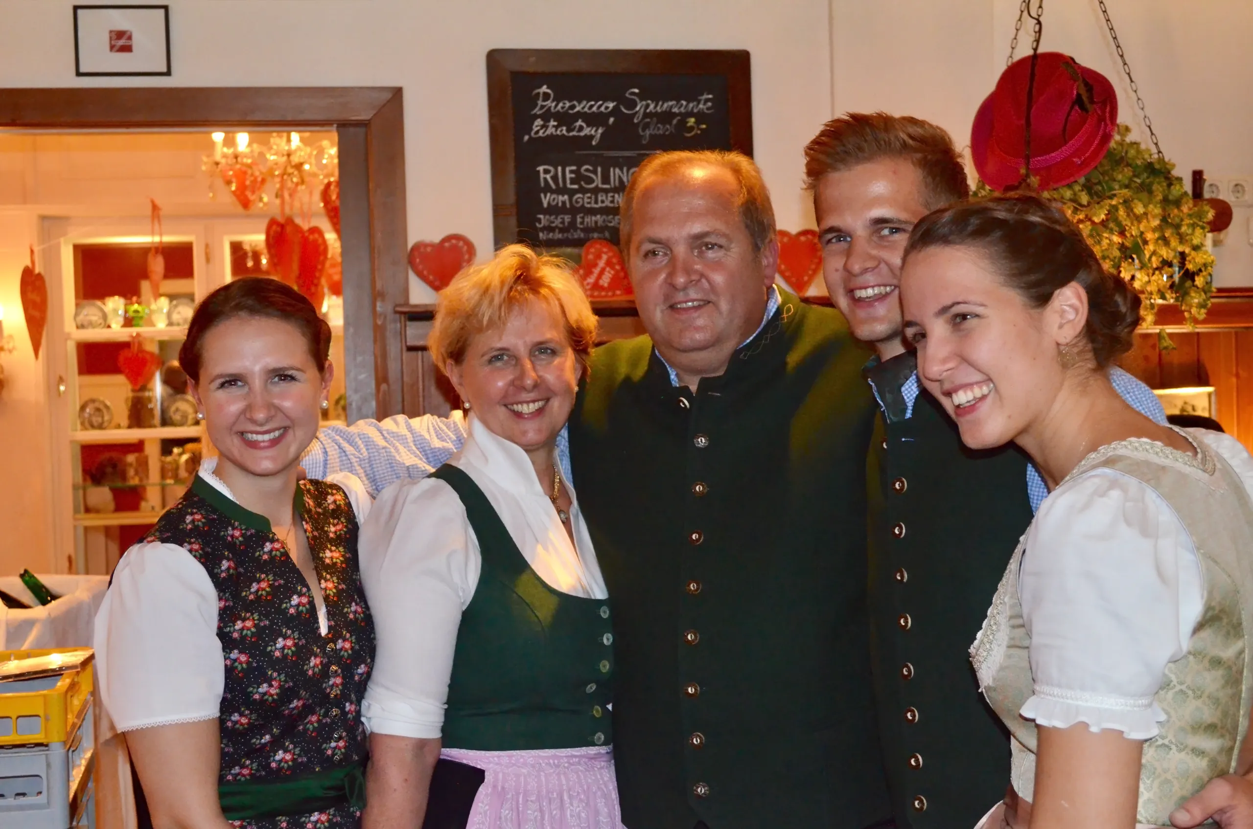 Group photo of traditionally dressed guests and hosts smiling at the camera
