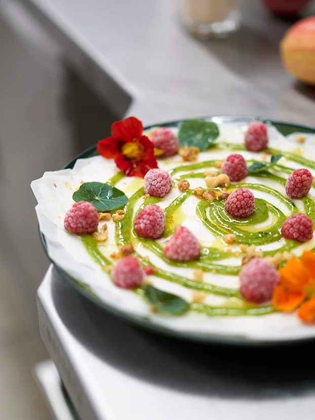 Joghurtcreme mit Himbeeren, Nüssen und grünem Fruchtpüree am Frühstücksbuffet.
